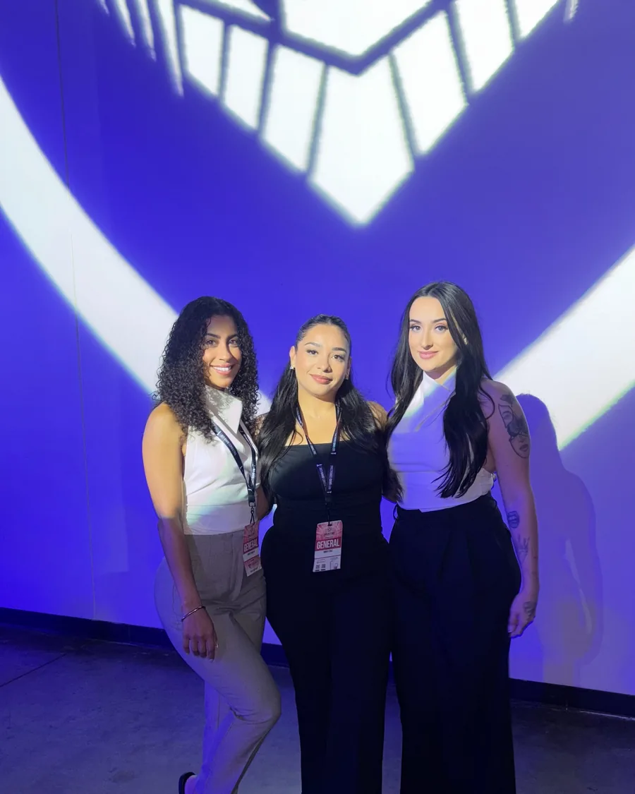 Three members photographed against the Alpha Society backdrop