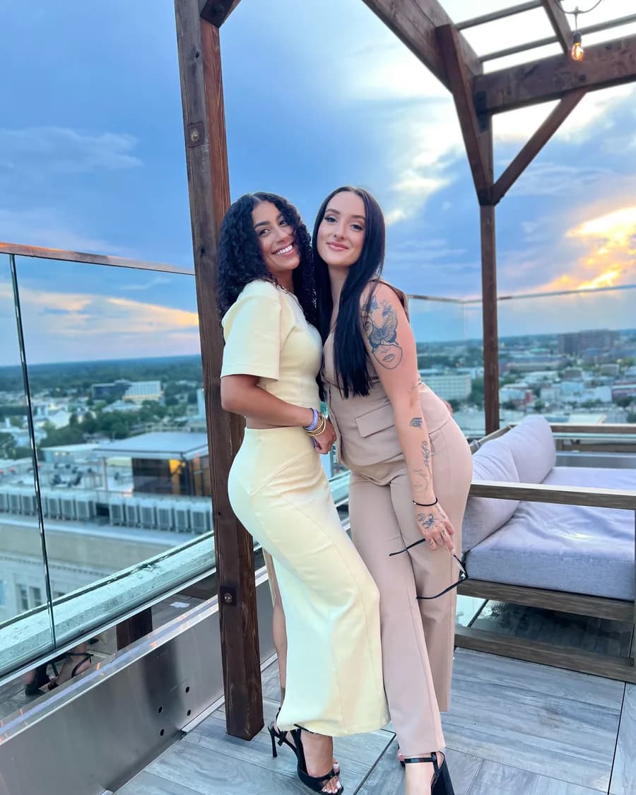 Rossy M. Peralta with a member on a rooftop terrace at sunset