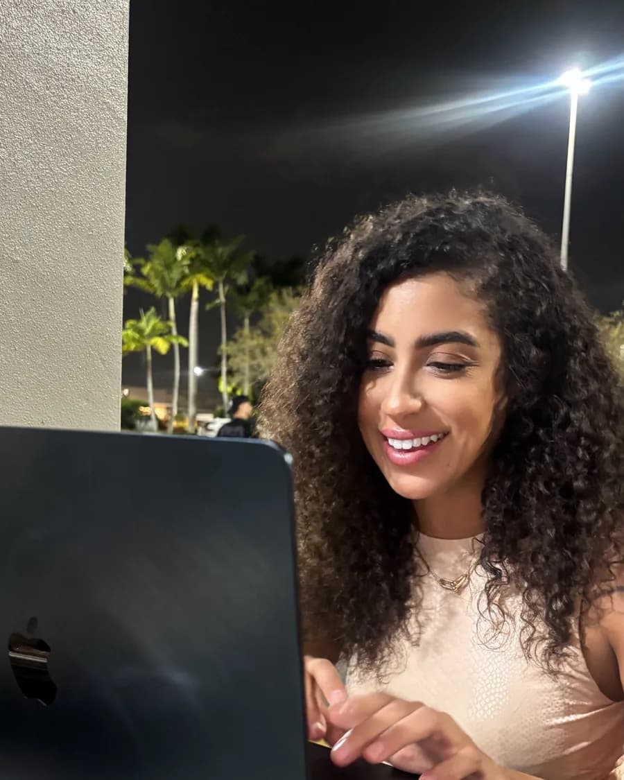 Rossy M. Peralta working on her laptop outdoors at night
